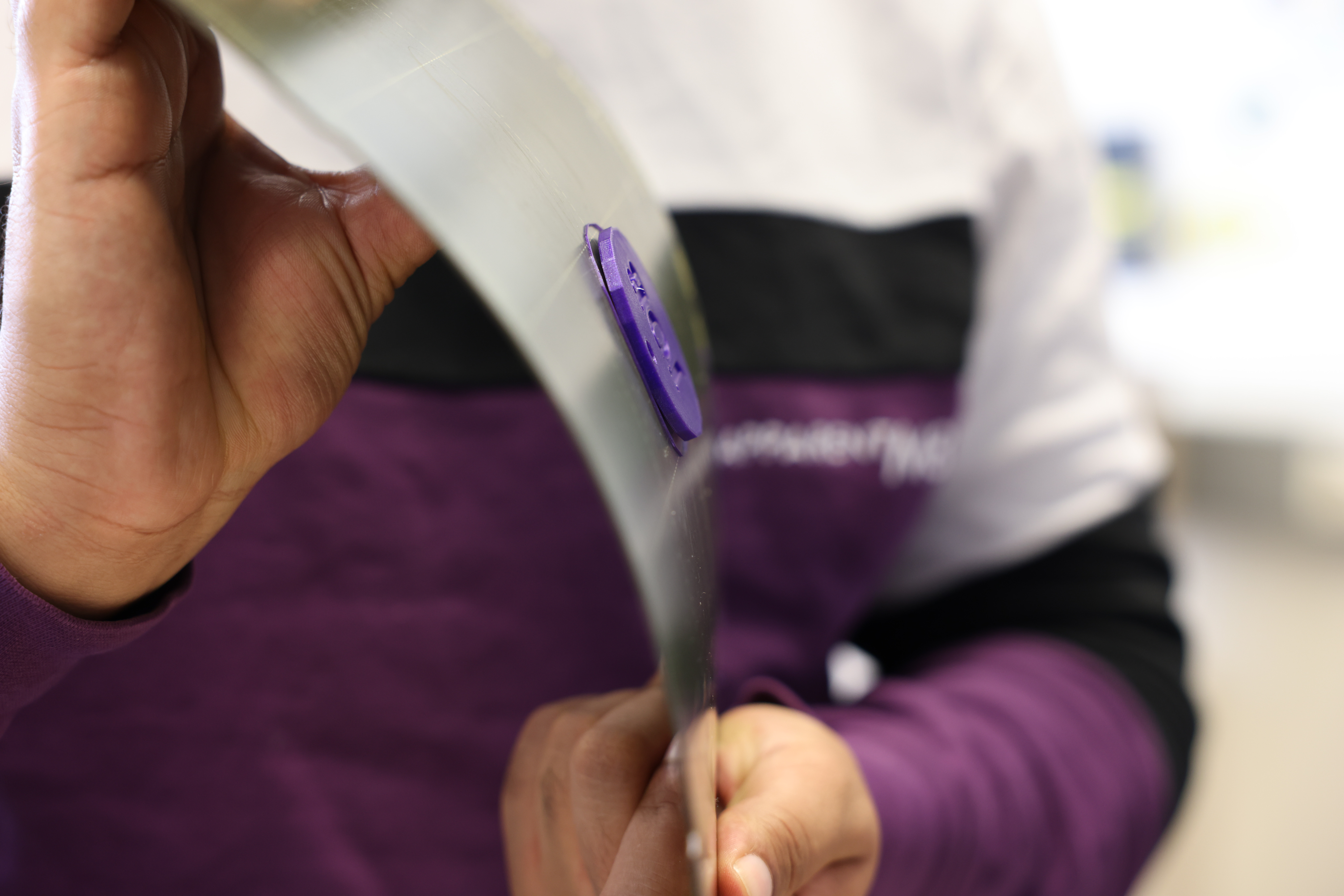 Foto einer Druckplatte, die von einer Person mit beiden Händen gebogen wird um das Druckobjekt zu lösen.